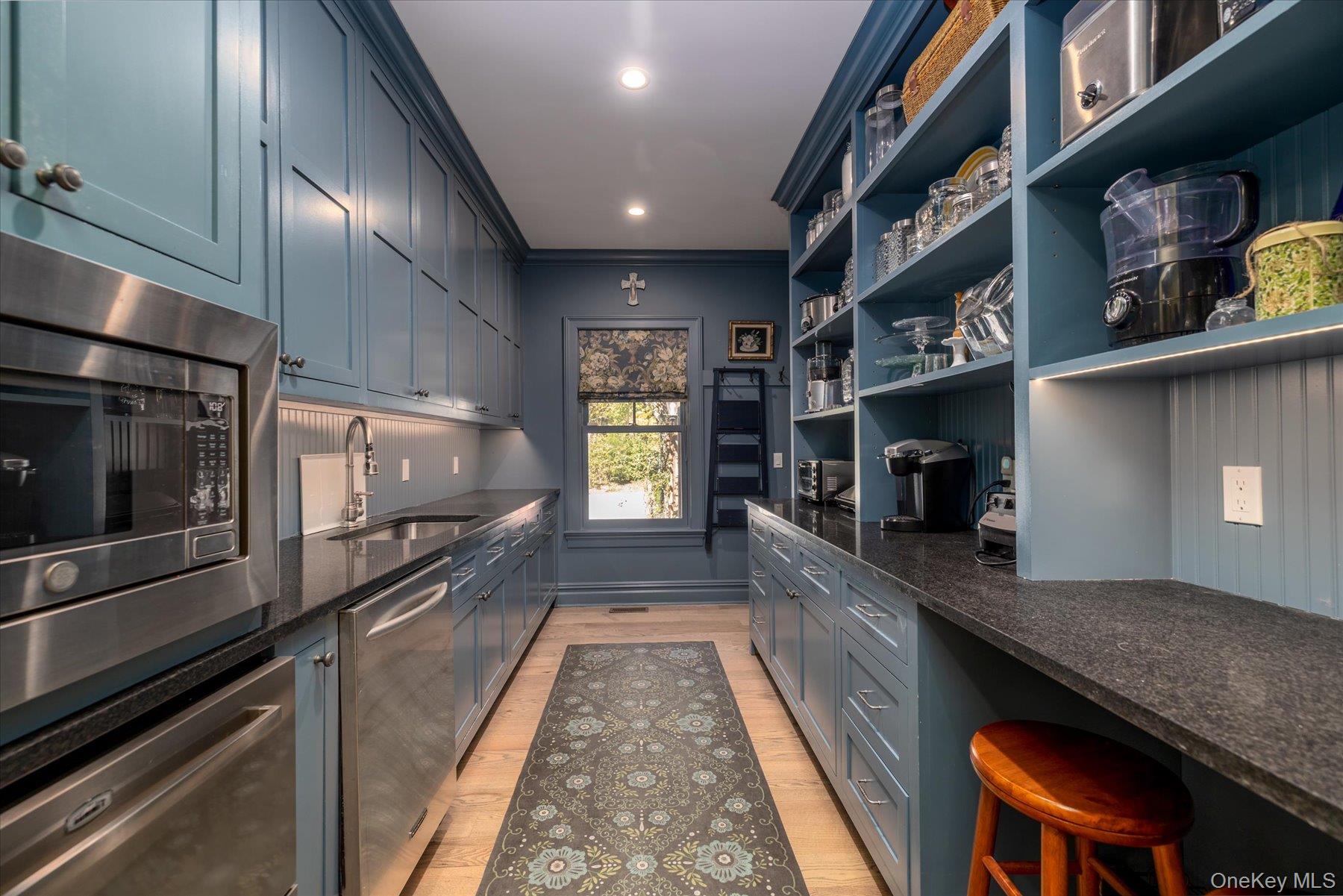 1750 Private Road, Unit 18 Mattituck, NY 11952 - Photo 29 of 49 a view of a kitchen with a sink and dishwasher a stove top oven with wooden floor