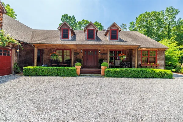 a view of a patio with plants and table and chairs under an umbrella