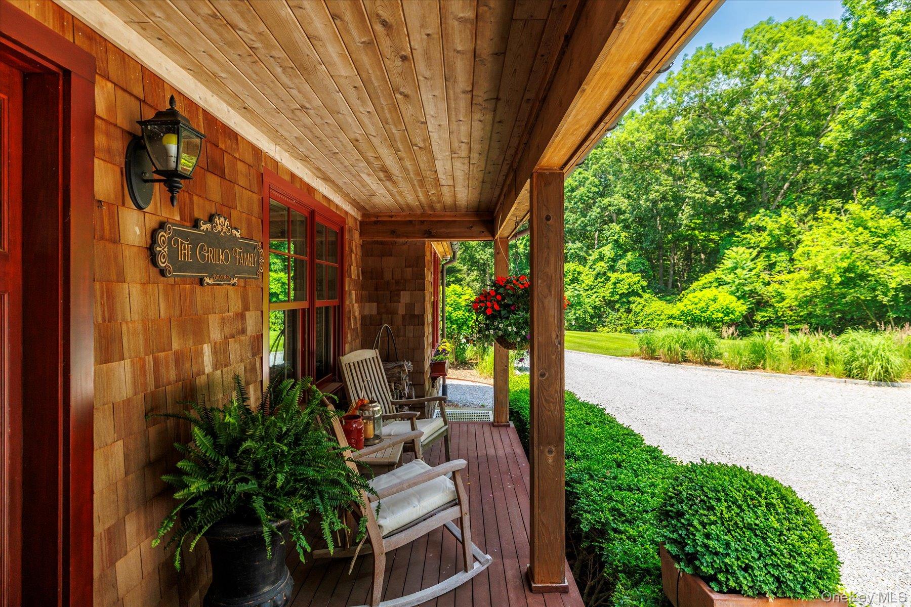 1750 Private Road, Unit 18 Mattituck, NY 11952 - Photo 6 of 49 a view of a patio with plants and table and chairs under an umbrella