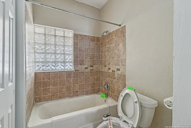 a bathroom with a granite countertop bathtub toilet and sink
