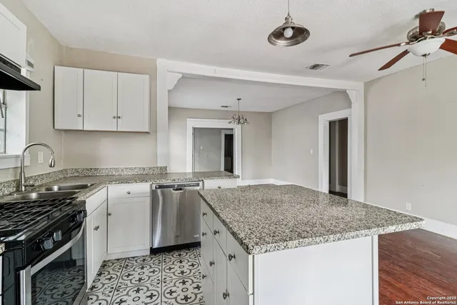 a kitchen with stainless steel appliances granite countertop a sink stove and cabinets
