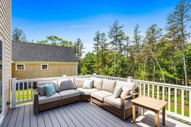 a balcony of a house with wooden floor and outdoor seating
