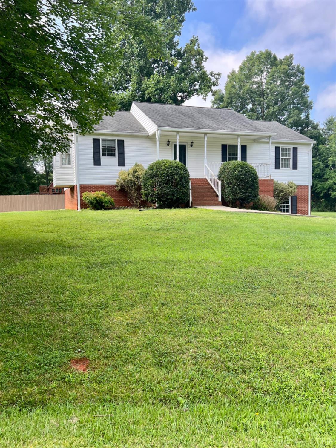 a front view of a house with a yard and trees