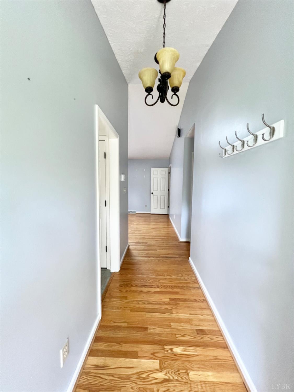202 Sugar Mill Drive Amherst, VA 24521 - Photo 7 of 41 a view of a hallway with wooden floor and a chandelier