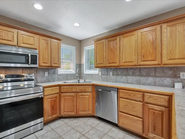 a kitchen with stainless steel appliances granite countertop a sink and cabinets