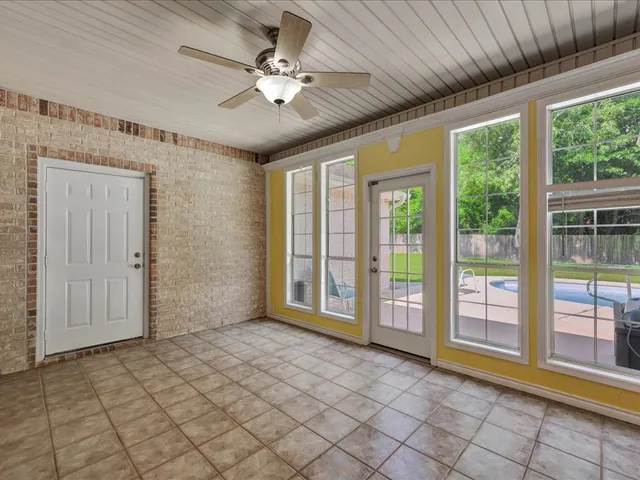 a view of an empty room with a chandelier fan
