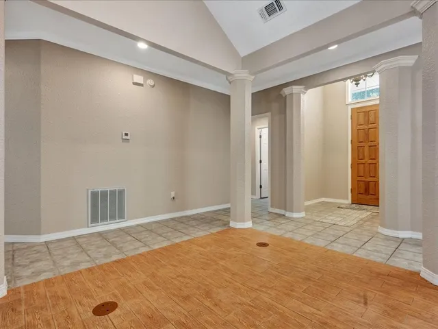 a view of an empty room with window and cabinet