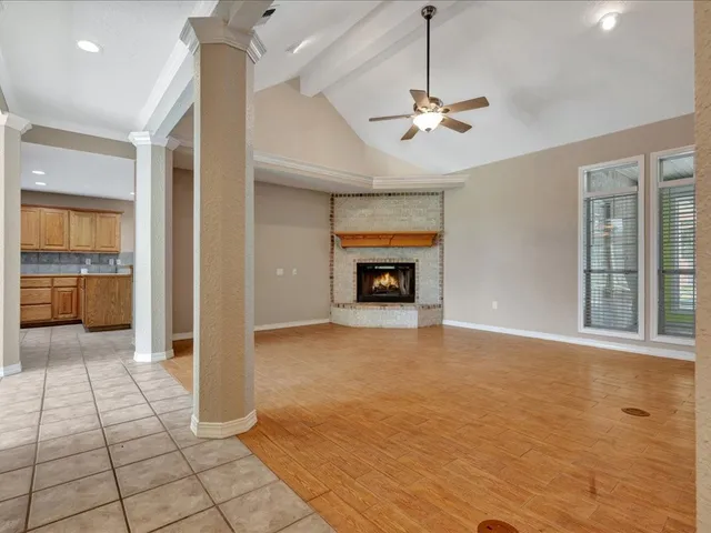 a view of an empty room with a fireplace and a window