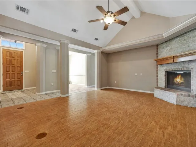 an empty room with a fireplace and chandelier