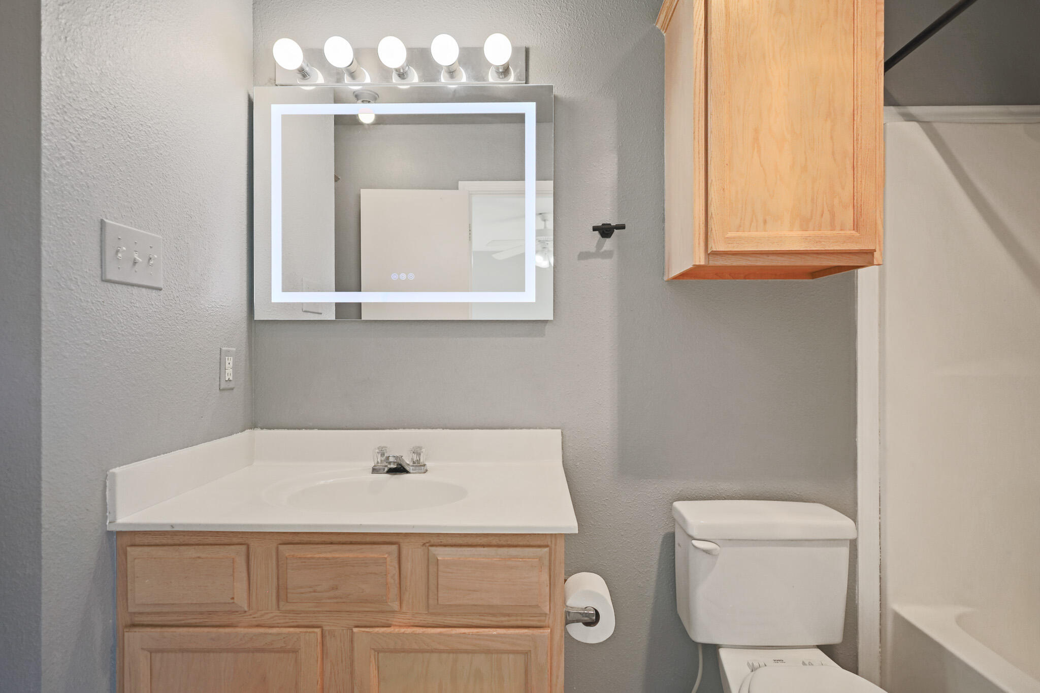 5903 10th Street, Unit 2 Lubbock, TX 79416 - Photo 25 of 47 a bathroom with a sink a toilet and a mirror
