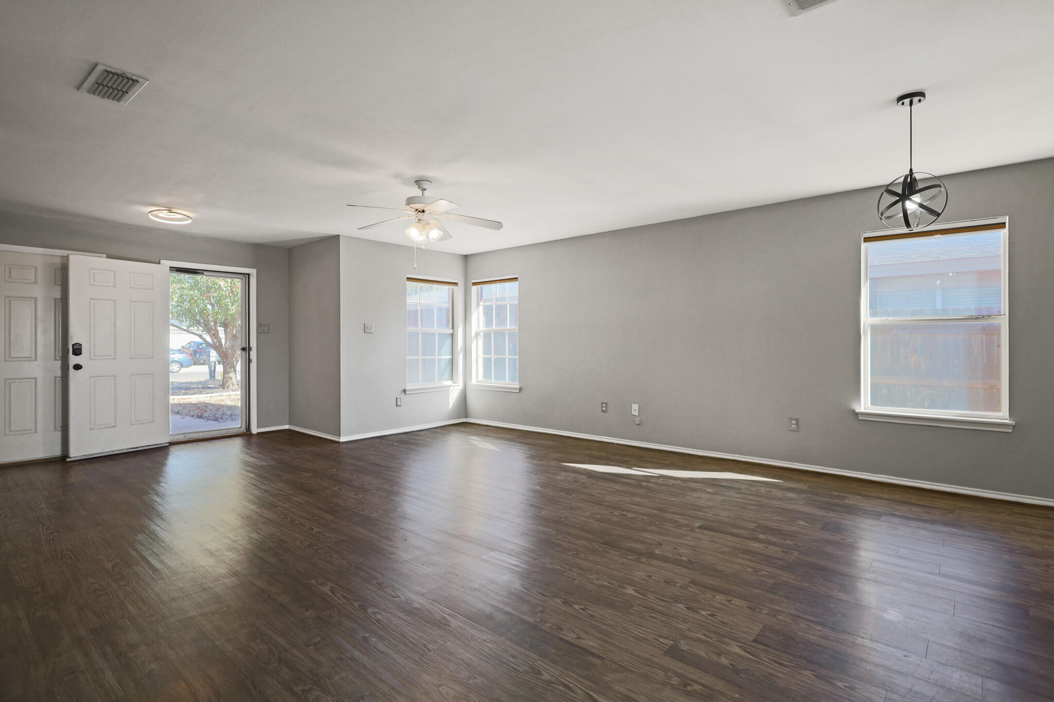 5903 10th Street, Unit 2 Lubbock, TX 79416 - Photo 5 of 47 a view of an empty room with a window and wooden floor