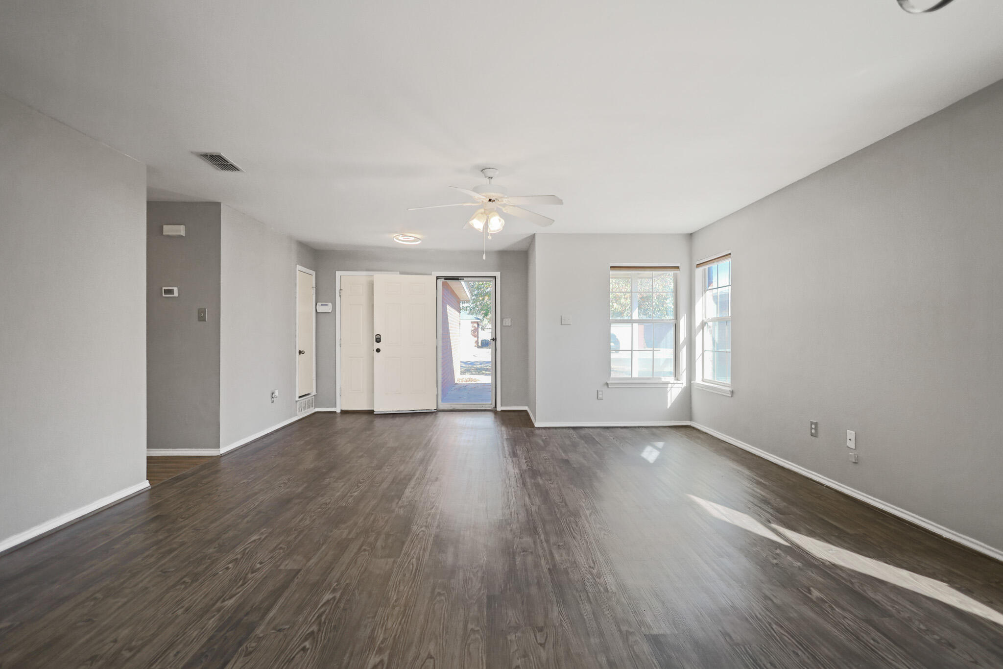 5903 10th Street, Unit 2 Lubbock, TX 79416 - Photo 6 of 47 a view of an empty room with wooden floor and window