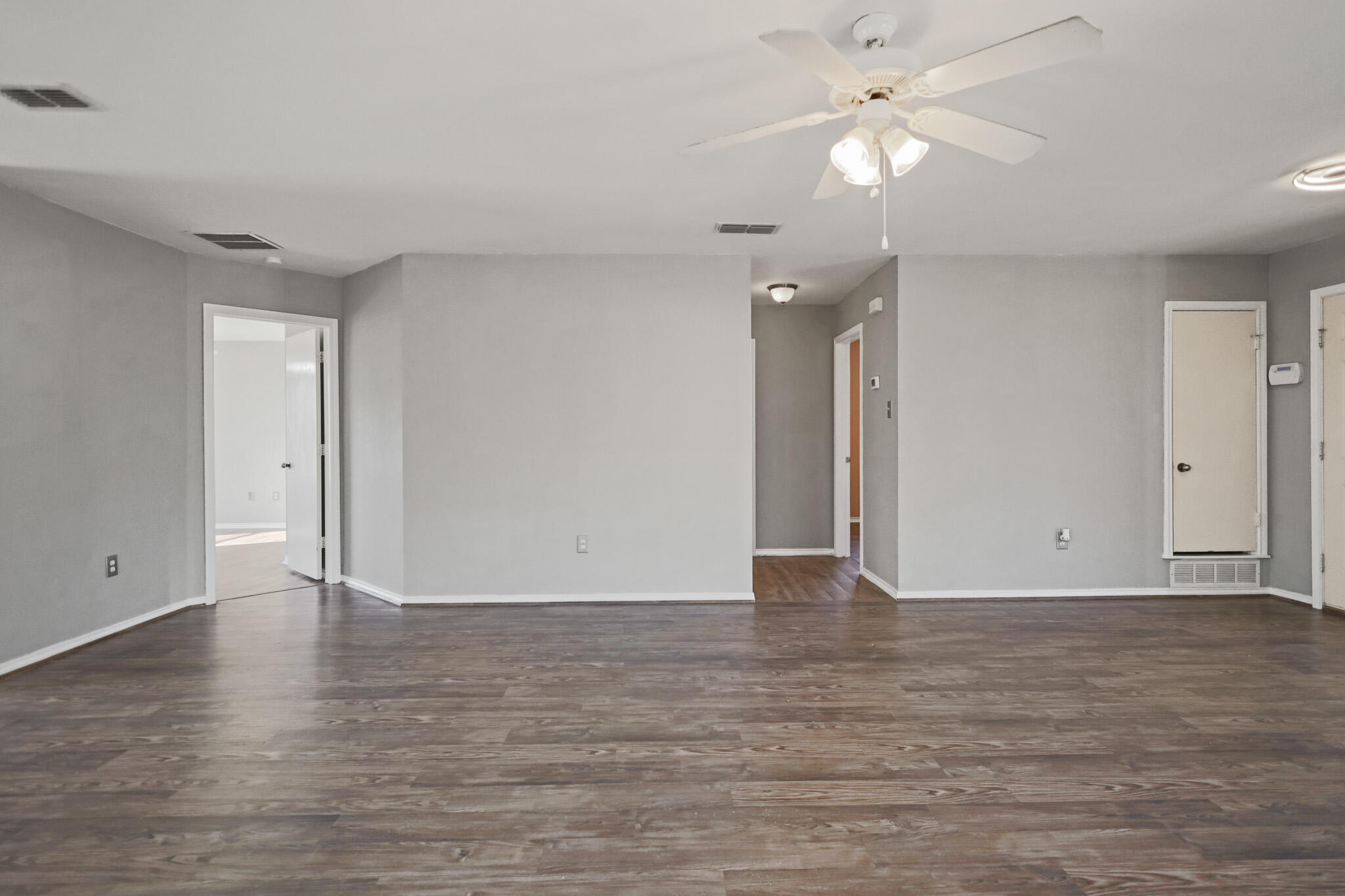 5903 10th Street, Unit 2 Lubbock, TX 79416 - Photo 8 of 47 an empty room with wooden floor and a ceiling fan