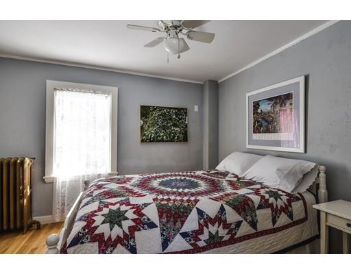 72 Main Street Framingham, MA 01702 - Photo 23 of 28 a bedroom with a bed and a chandelier