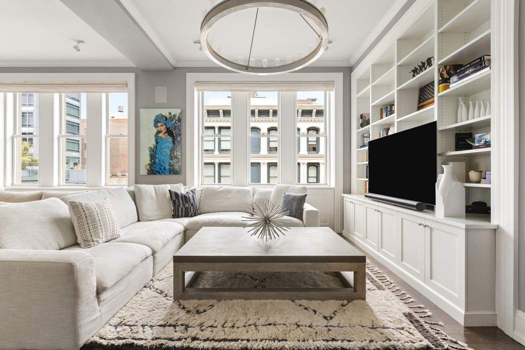 458 Broadway, Unit 6 Manhattan, NY 10013 - Photo 3 of 18 a living room with furniture a flat screen tv and a floor to ceiling window