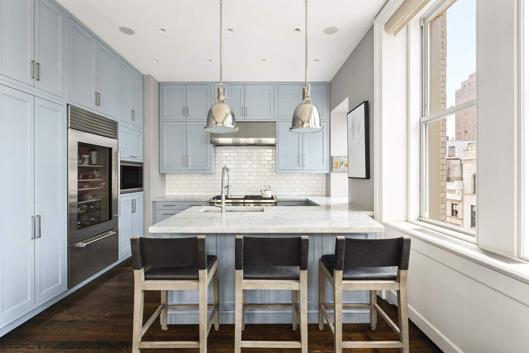 458 Broadway, Unit 6 Manhattan, NY 10013 - Photo 6 of 18 a kitchen with kitchen island a table and chairs in it
