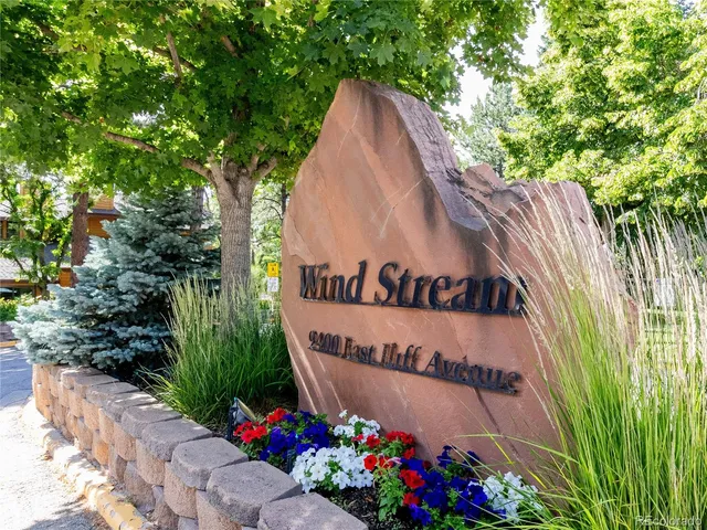 a patio with table and chairs and a large tree