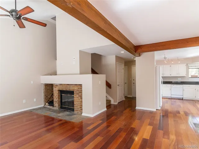 a view of a livingroom with wooden floor and a fireplace