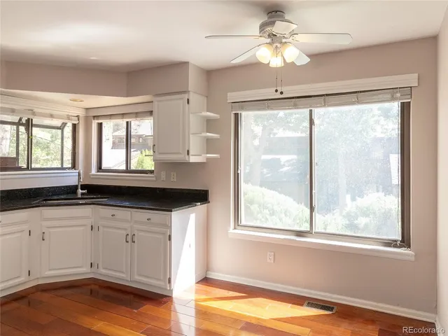 a kitchen with granite countertop a large window sink and cabinets