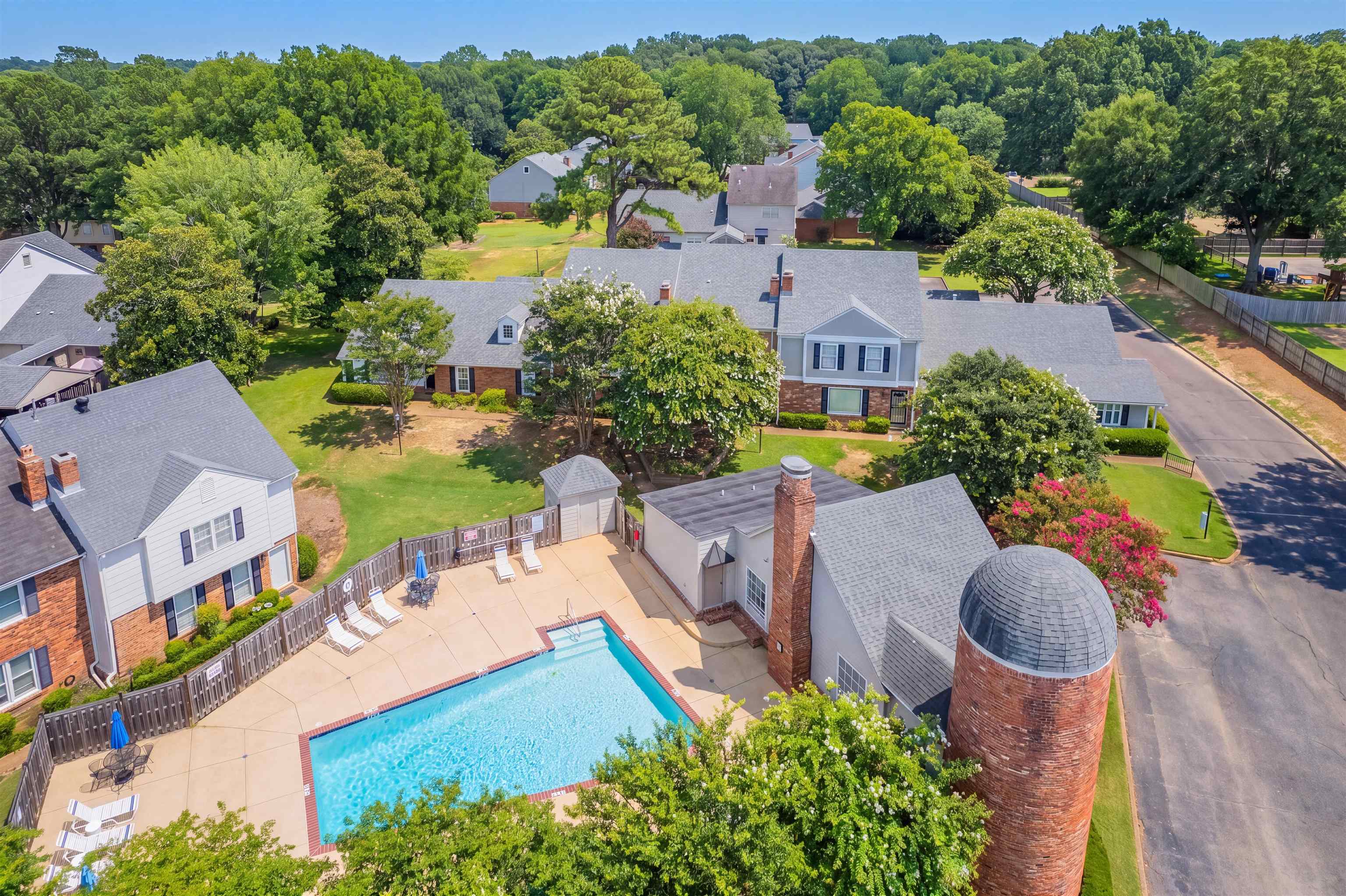 6943 Fords Station Road, Unit 64 Germantown, TN 38138 - Photo 17 of 30 Community swimming pool with surrounding patio space, a privacy fence, and an adjacent brick silo-style structure