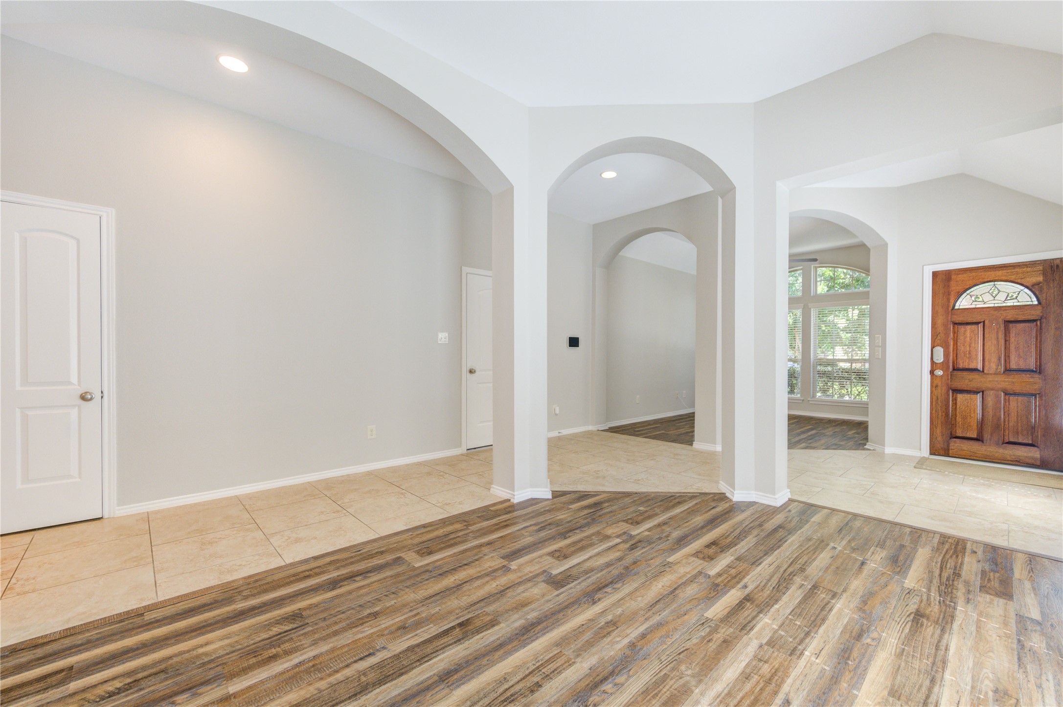 27407 Gatlin Lane Spring, TX 77386 - Photo 11 of 35 This view showcases the home's thoughtful layout, where elegant archways and soaring ceilings create a seamless connection between the foyer, dining area, and flexible living spaces. The open design offers endless possibilities for entertaining, working from home, or everyday living while maintaining a bright, spacious feel throughout.