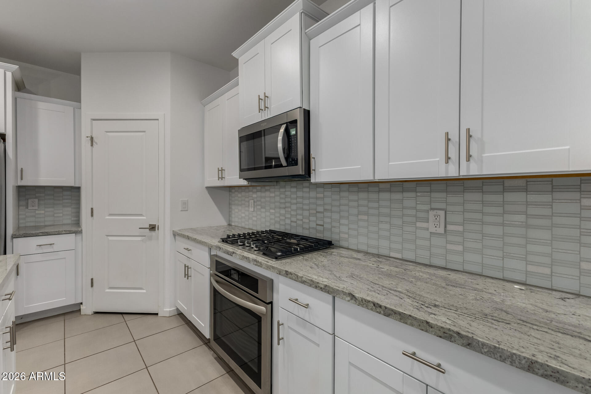 4337 East Italian Trotter Road San Tan Valley, AZ 85140 - Photo 16 of 35 a kitchen with granite countertop white cabinets stainless steel appliances and sink