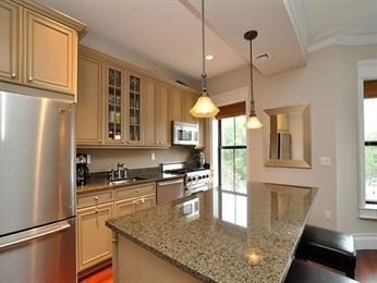684 Tremont Street, Unit 5 Boston, MA 02118 - Photo 2 of 10 a kitchen with stainless steel appliances granite countertop a refrigerator a sink dishwasher a stove and a dining table with wooden floor