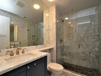 684 Tremont Street, Unit 5 Boston, MA 02118 - Photo 7 of 10 a bathroom with a granite countertop sink a toilet a mirror and shower
