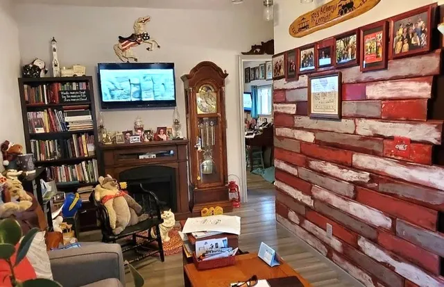 a living room with furniture a bookshelf and a painting on the wall