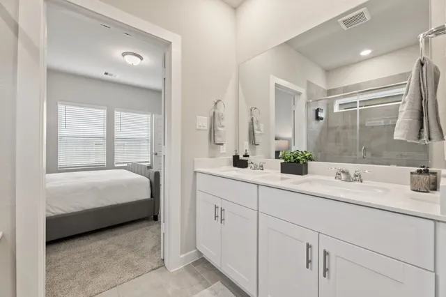 a spacious bathroom with a double vanity sink mirror and cabinet