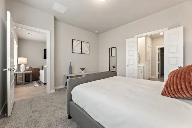 a spacious bedroom with a bed and a view of bathroom