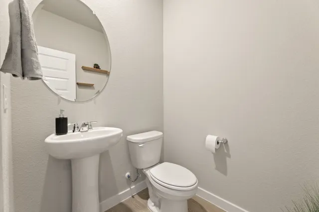 a bathroom with a sink toilet and a mirror