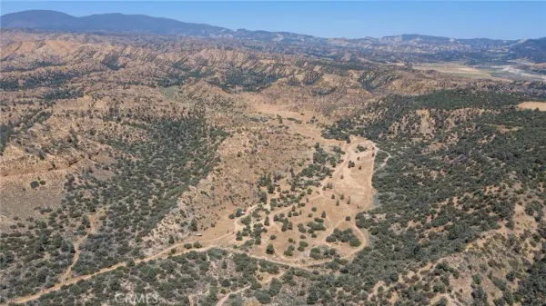 a view of a dry yard with mountains in the background