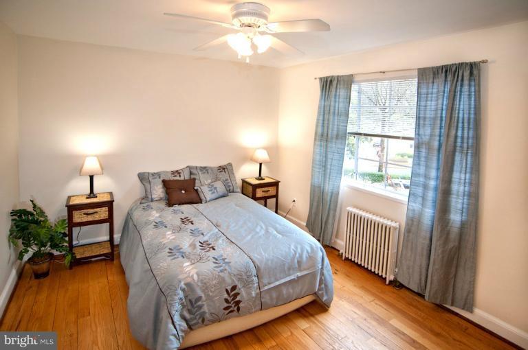 8722 Manchester Road, Unit 7 Silver Spring, MD 20901 - Photo 12 of 16 a bedroom with a bed and a chandelier