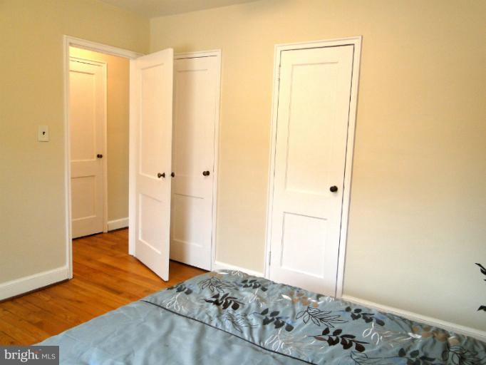 8722 Manchester Road, Unit 7 Silver Spring, MD 20901 - Photo 13 of 16 a bedroom with a bed and a walk in closet