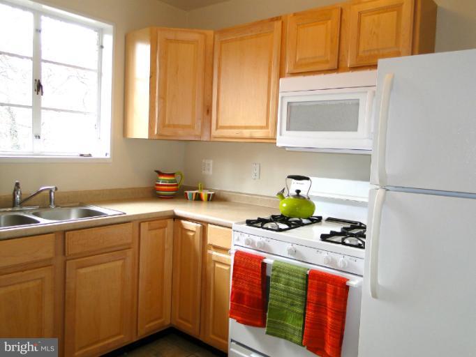 8722 Manchester Road, Unit 7 Silver Spring, MD 20901 - Photo 8 of 16 a kitchen with stainless steel appliances a sink a stove and cabinets
