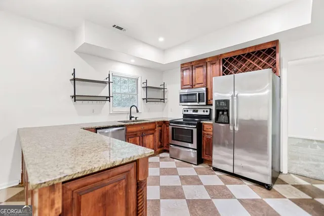 a kitchen with granite countertop stainless steel appliances a sink and cabinets