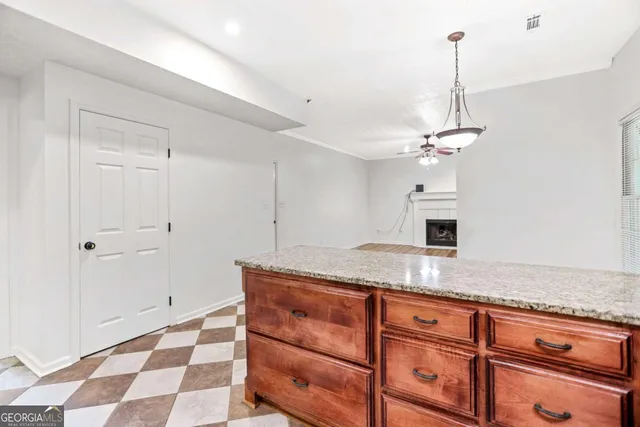 a view of an empty room with a kitchen and wooden floor