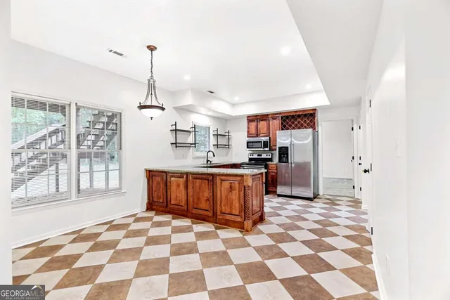 a view of an empty room with wooden floor fireplace and a window