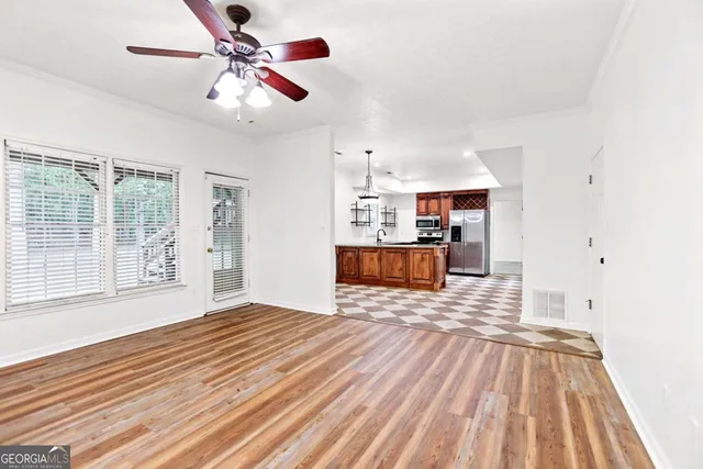 en empty room with windows and ceiling fan