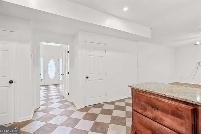 a view of an empty room and chandelier fan