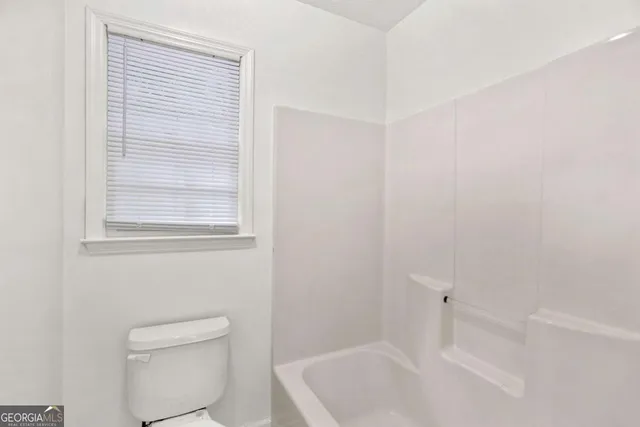 a bathroom with a toilet and a shower