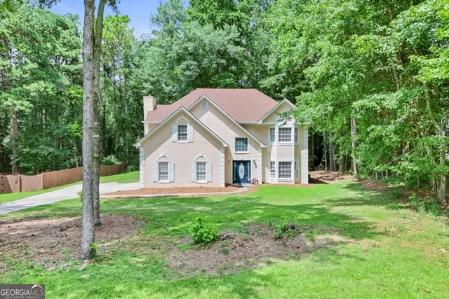 a front view of a house with a yard and trees