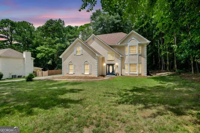 a view of a house with backyard and trees