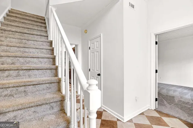 a view of a hallway with wooden floor and a bathroom