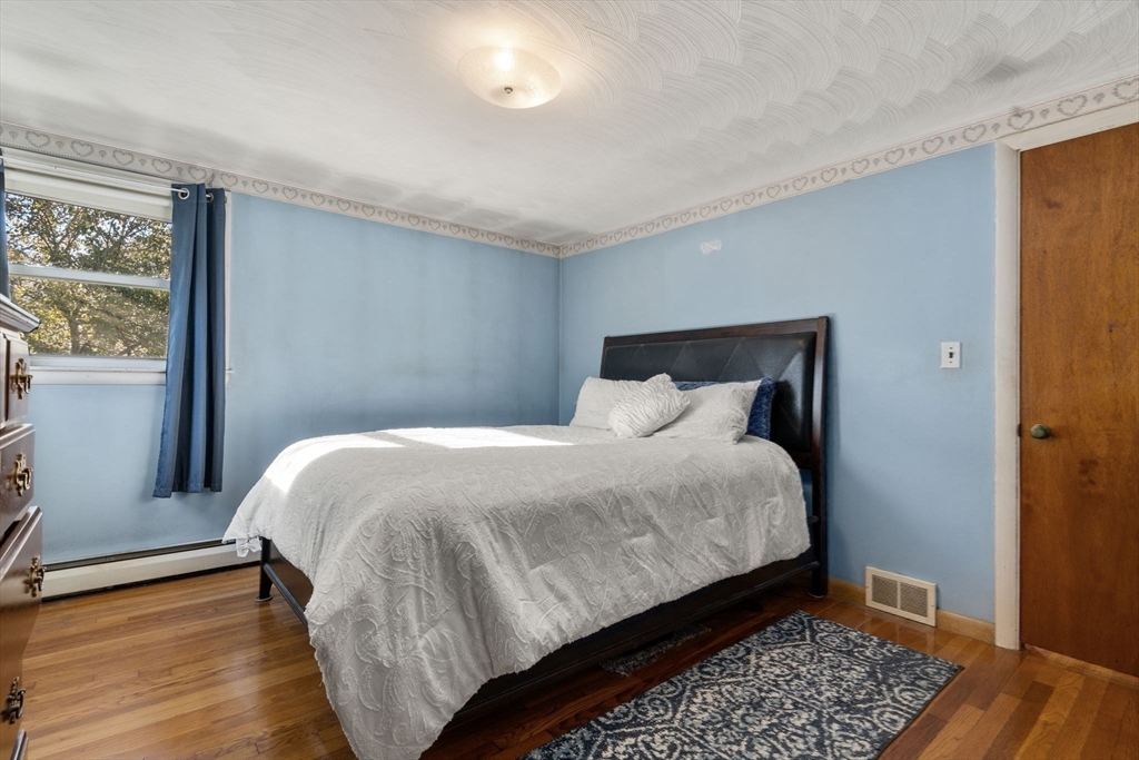 30 Wampum Avenue Waltham, MA 02451 - Photo 17 of 29 a bedroom with a bed and wooden floor