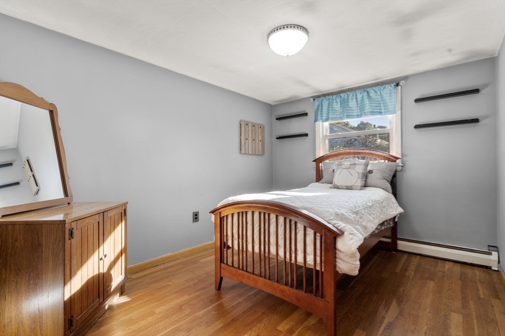 30 Wampum Avenue Waltham, MA 02451 - Photo 19 of 29 a bedroom with a bed and wooden floor