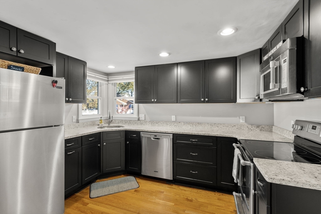 30 Wampum Avenue Waltham, MA 02451 - Photo 5 of 29 a kitchen with stainless steel appliances granite countertop a refrigerator a sink and a stove