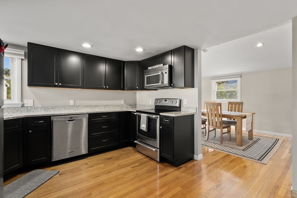 30 Wampum Avenue Waltham, MA 02451 - Photo 6 of 29 a kitchen with stainless steel appliances kitchen island granite countertop a stove and a sink