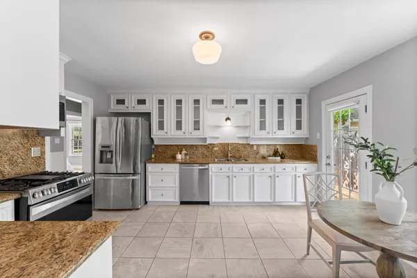 a kitchen with a refrigerator and a stove top oven